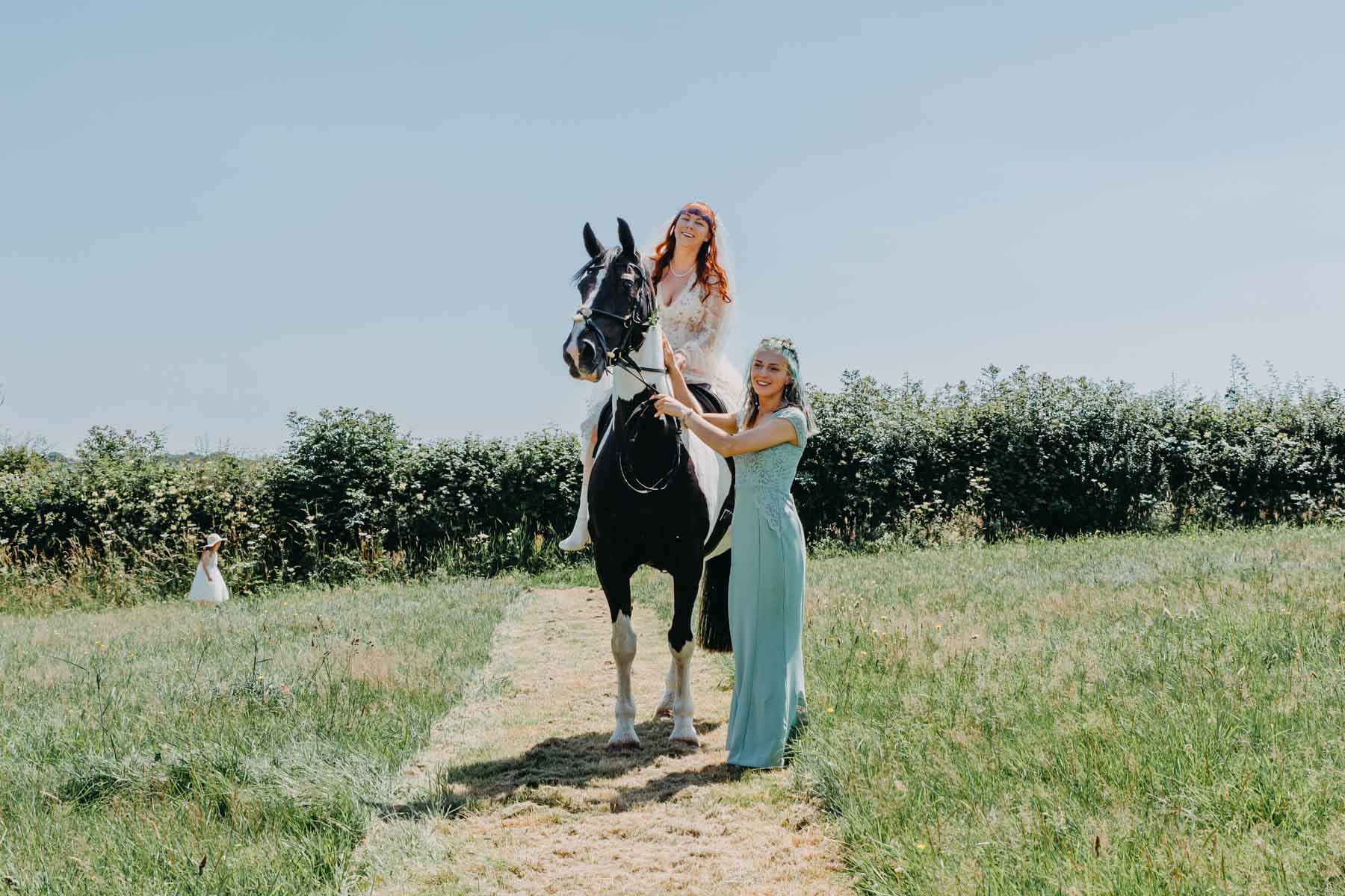 the bridesmaid leads the bride sitting on horseback to the handfasting ceremony