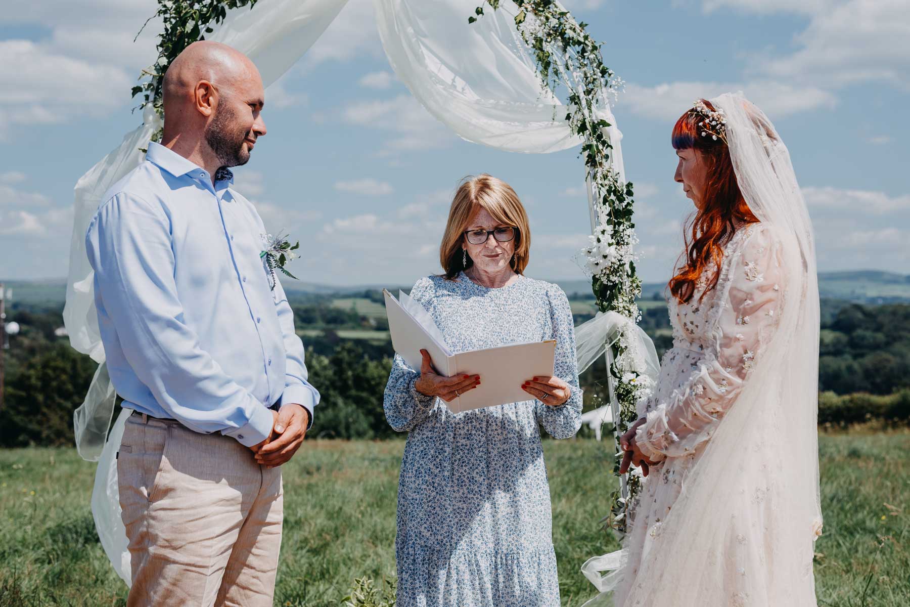 The groom, the bride and their handfasting ceremony celebrant
