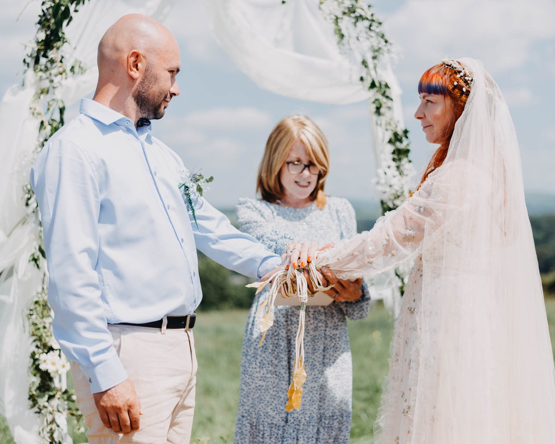 Bride and groom having a handfasting ceremony