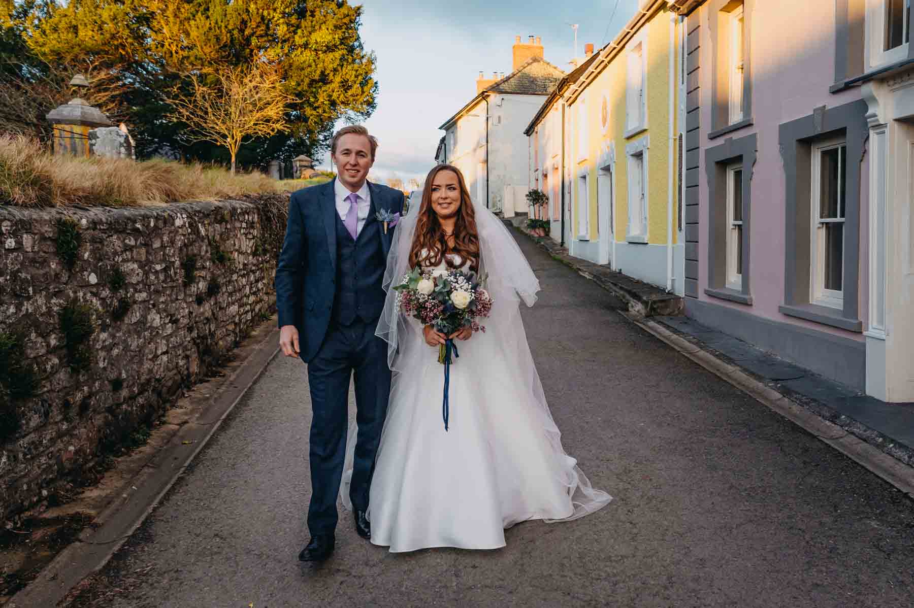 Bride and Groom walking on the street in Myddfai - natural wedding photography Wales