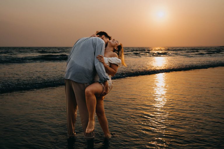 Couple on the beach at sunset during the engagement photoshoot Wales