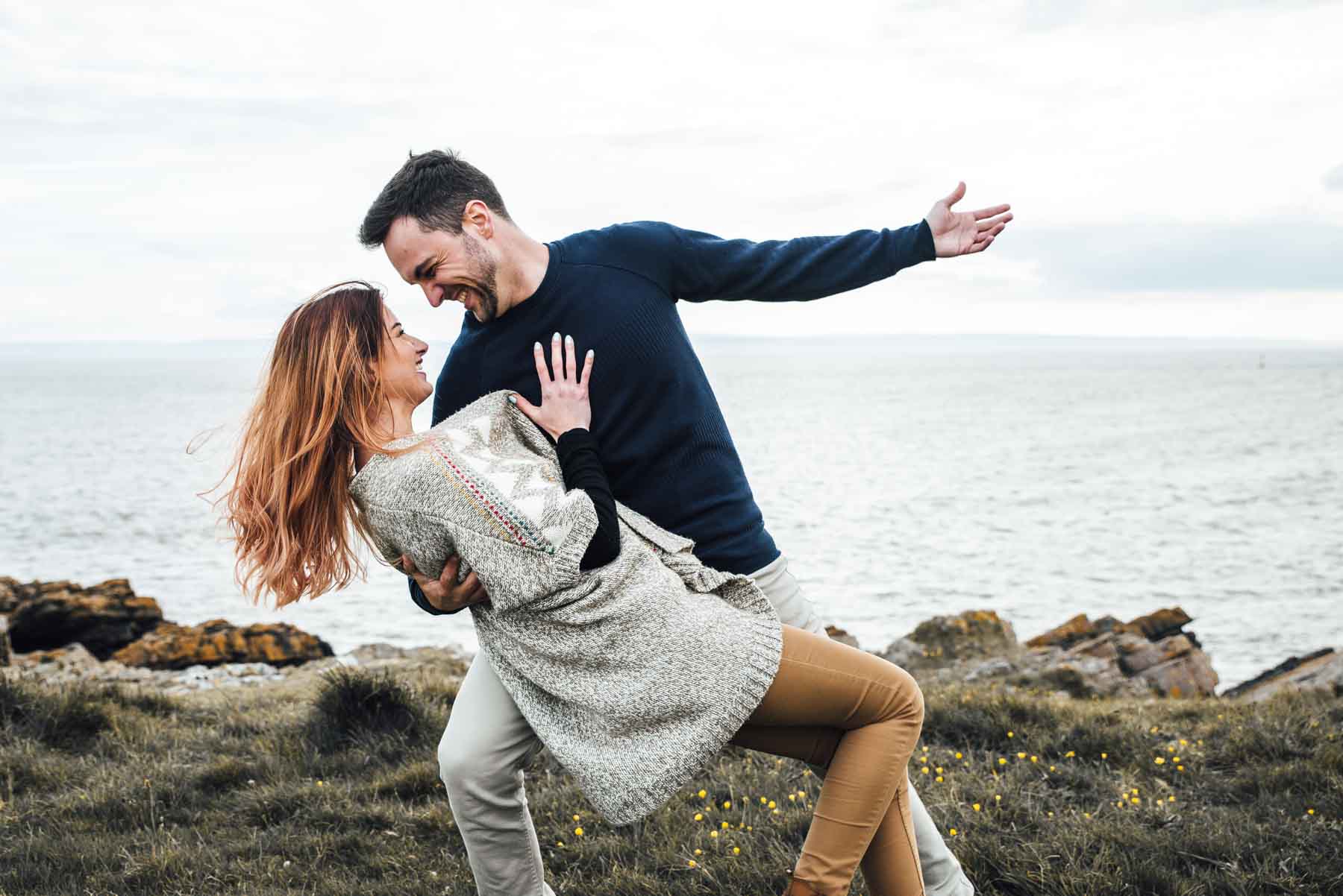 Couple Photoshoot - Wedding Photography Couple dances on the rocks by the sea