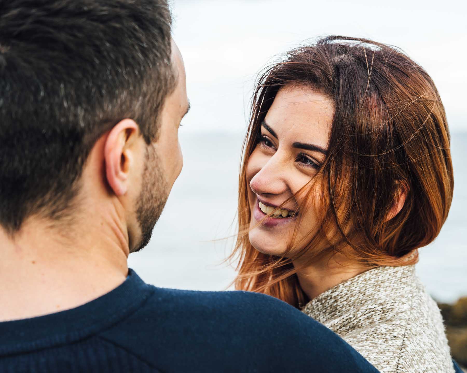 Smiling girl looks into the eyes of her boyfriend