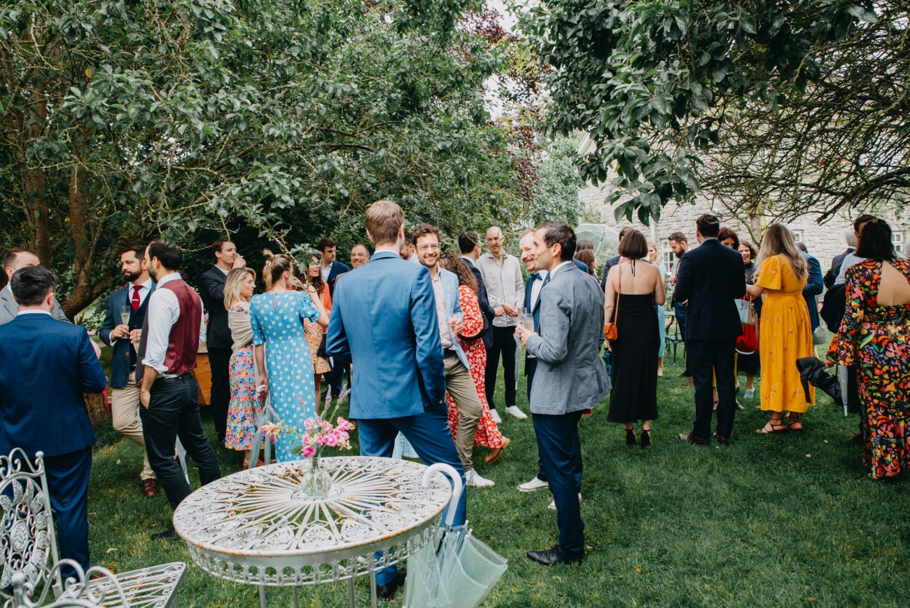 Guests enjoying a relaxed outdoor gathering under the trees at a festival wedding at Splotts Moor in Glastonbury.