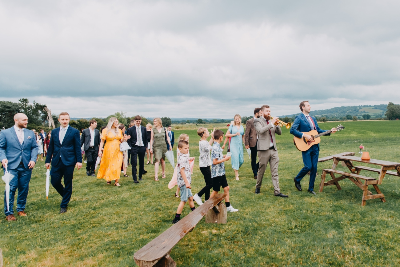 Wedding guests procession at festival-themed wedding in Glastonbury.