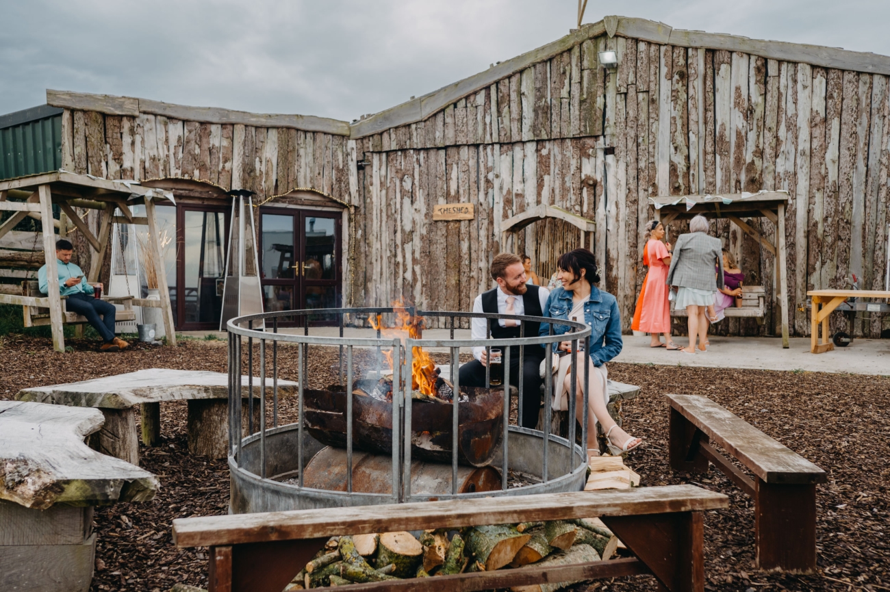 The Shed at Mwnt, a rustic barn wedding venue in Wales, featuring an outdoor fire pit and scenic sea views, perfect for intimate and unique weddings in a secluded setting.