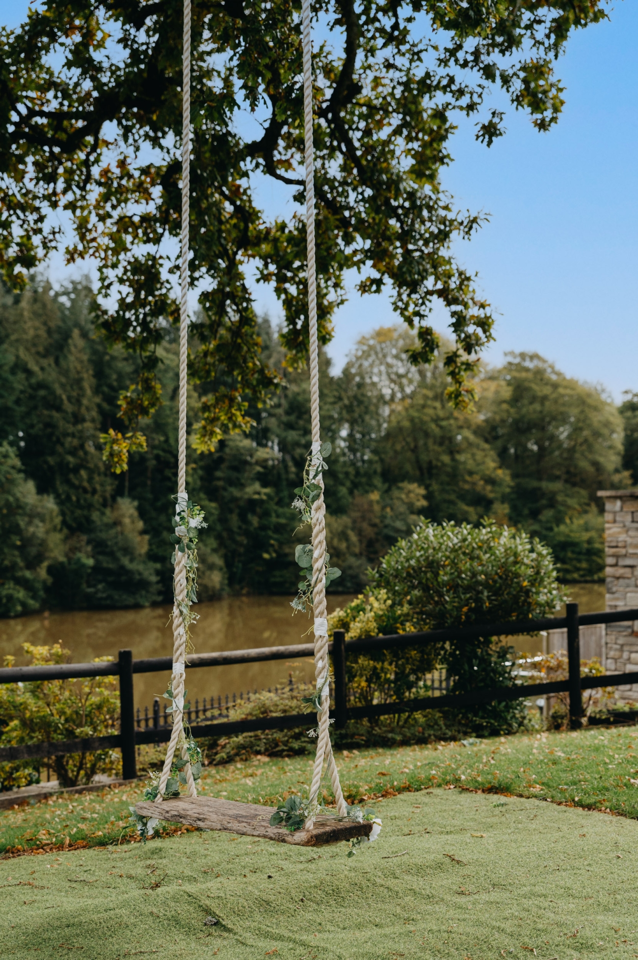Romantic swing decorated with greenery at Canada Lodge & Lake, perfect for wedding photography and outdoor ceremonies by the lake.