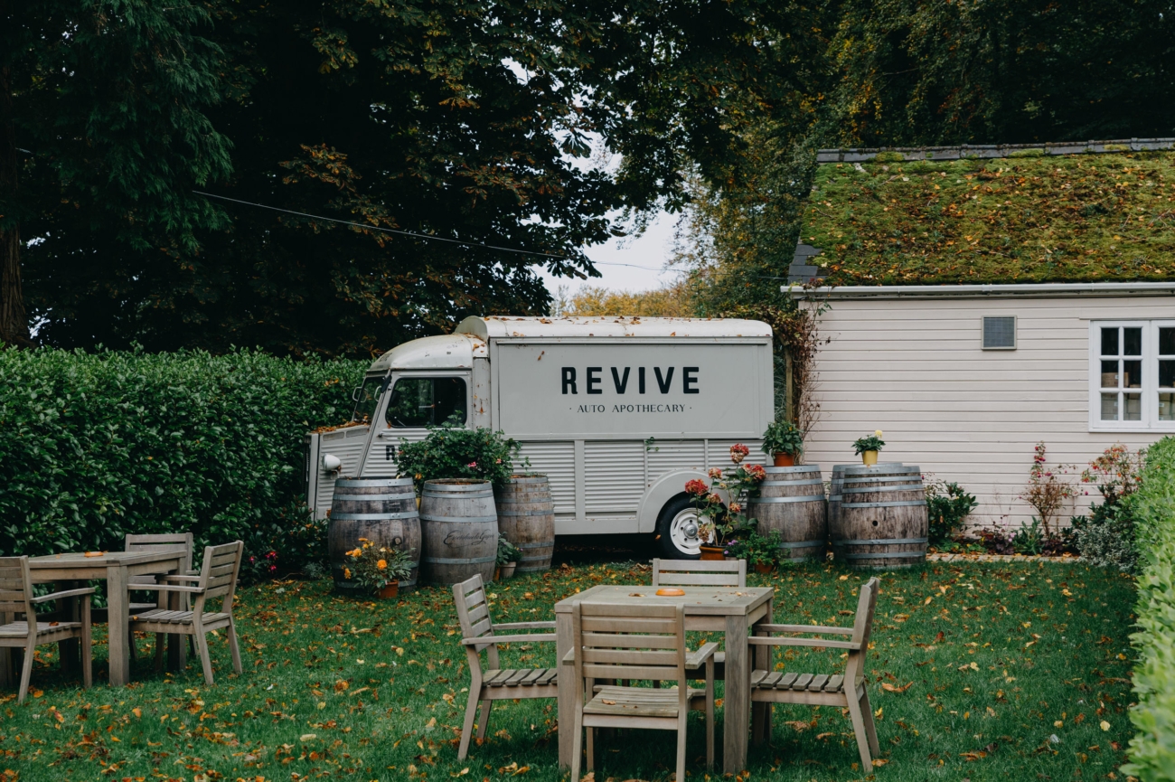 Rustic outdoor decor featuring a vintage van and wooden barrels at Coed-Y-Mwstwr Hotel, a scenic wedding venue in South Wales, ideal for outdoor celebrations.
