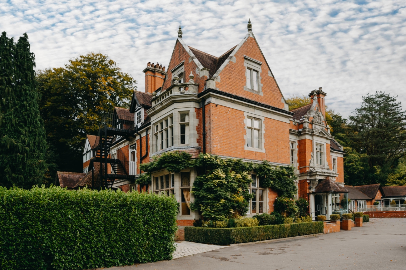 Exterior of Coed-Y-Mwstwr Hotel, a historic wedding venue near Bridgend, featuring ivy-covered brick walls and a classic, elegant design perfect for weddings.