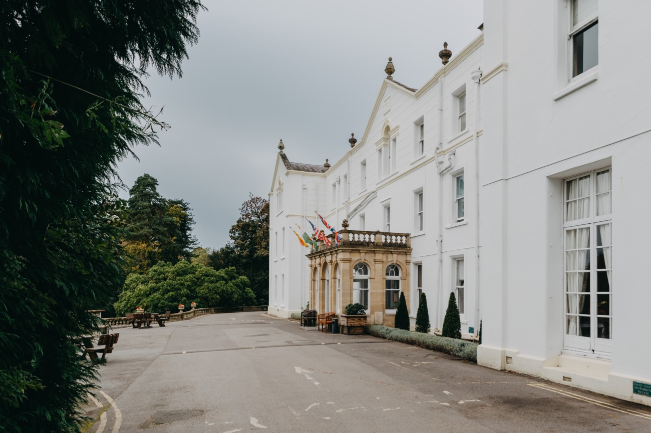 A side view of Court Colman Manor, showcasing its elegant white exterior and stately architecture, making it a popular wedding venue near Bridgend.