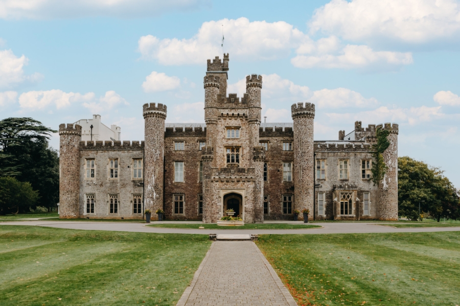 The grand front entrance of Hensol Castle, a historic and elegant wedding venue in South Wales, surrounded by lush green grounds.