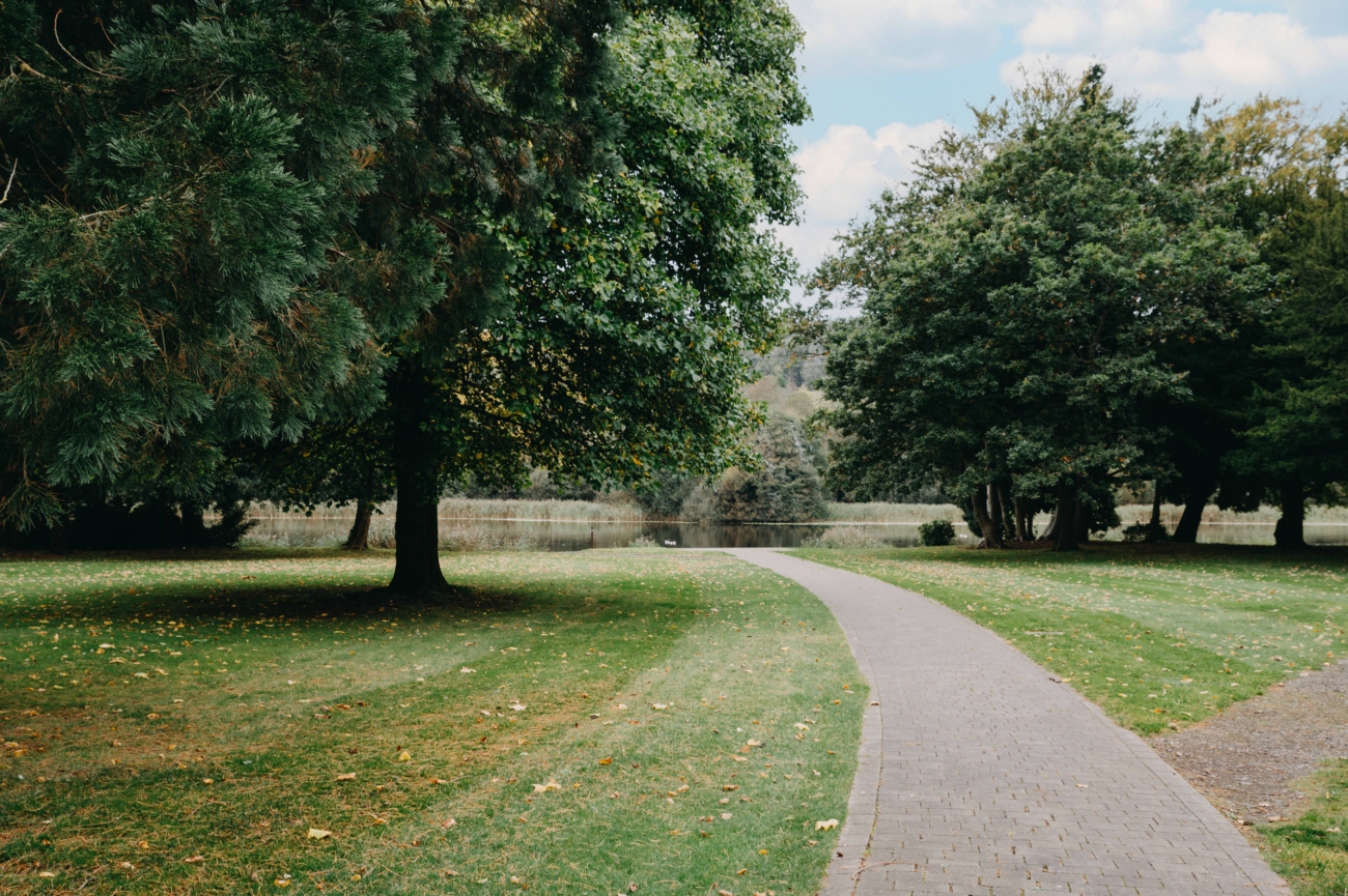 A serene garden pathway at Hensol Castle, a beautiful wedding venue in South Wales, surrounded by lush greenery, perfect for wedding photography.