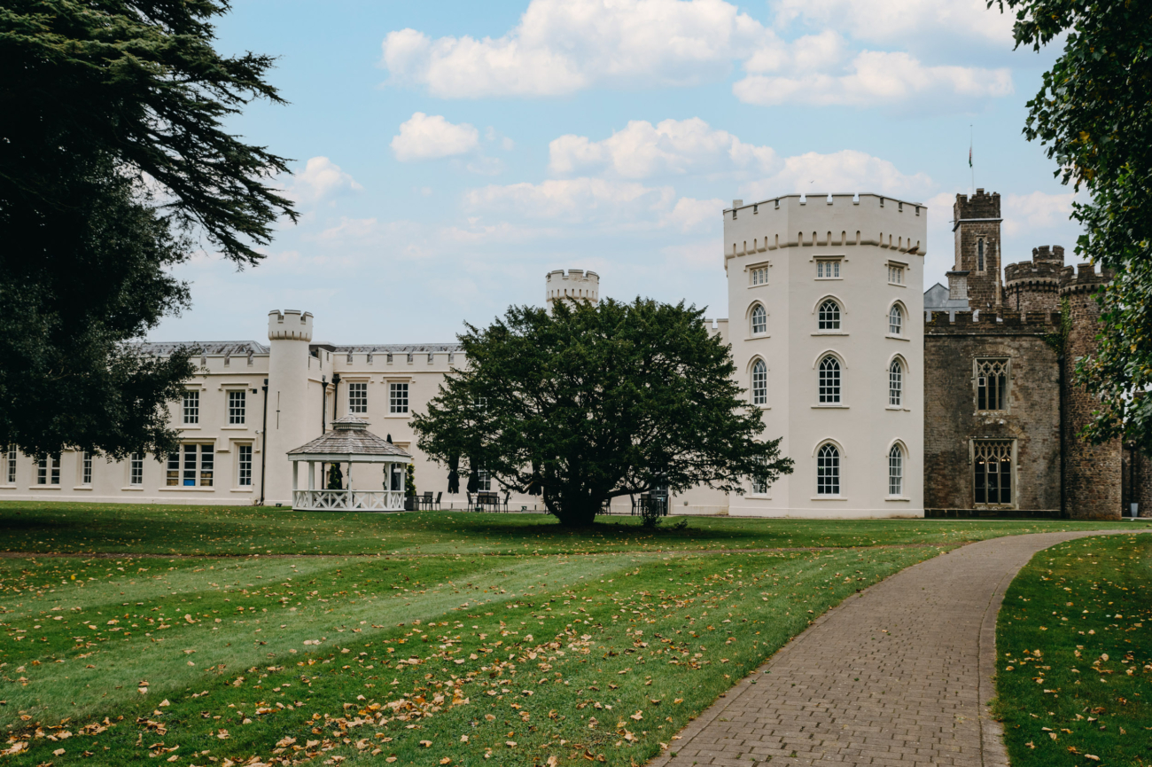The elegant grounds of Hensol Castle in South Wales, featuring a charming gazebo and a pathway leading through the lush landscape, perfect for wedding ceremonies.