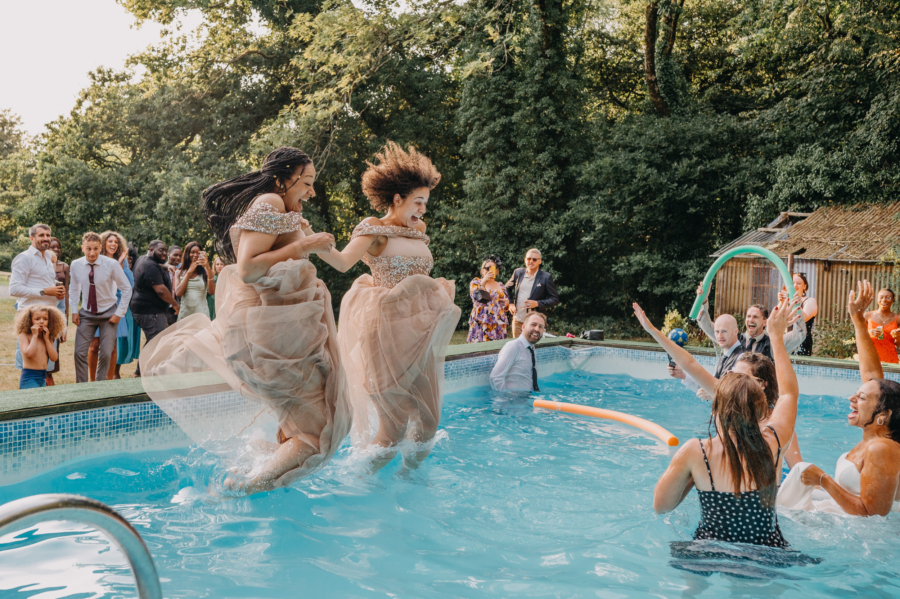 Wedding guests joyfully jumping into a pool, creating a fun and unforgettable guest experience at an outdoor wedding celebration.