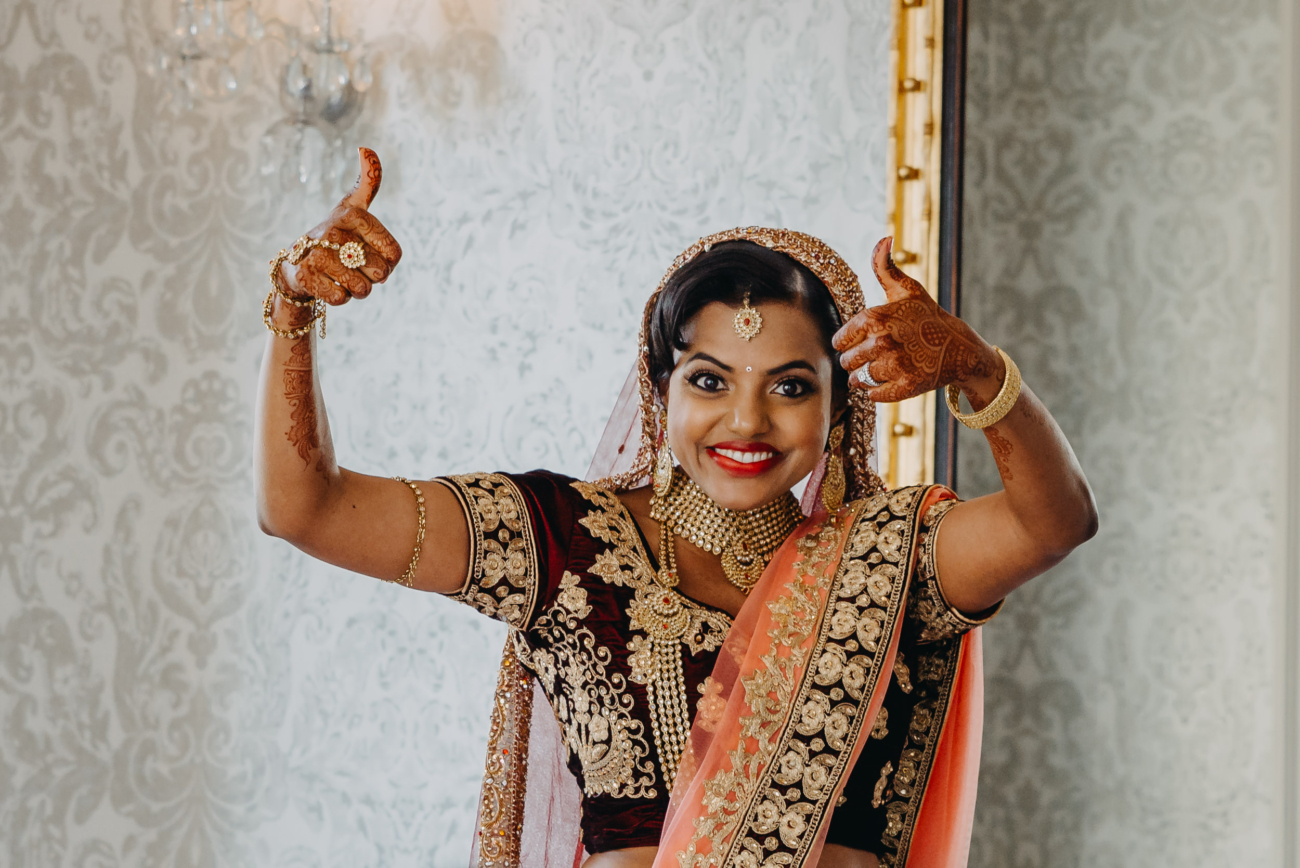 Happy bride in traditional wedding attire, pleased with finding a reliable wedding photographer.