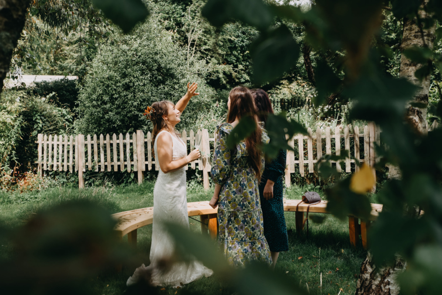 Bride laughing and chatting with guests outdoors, captured in a candid moment by a reliable wedding photographer.