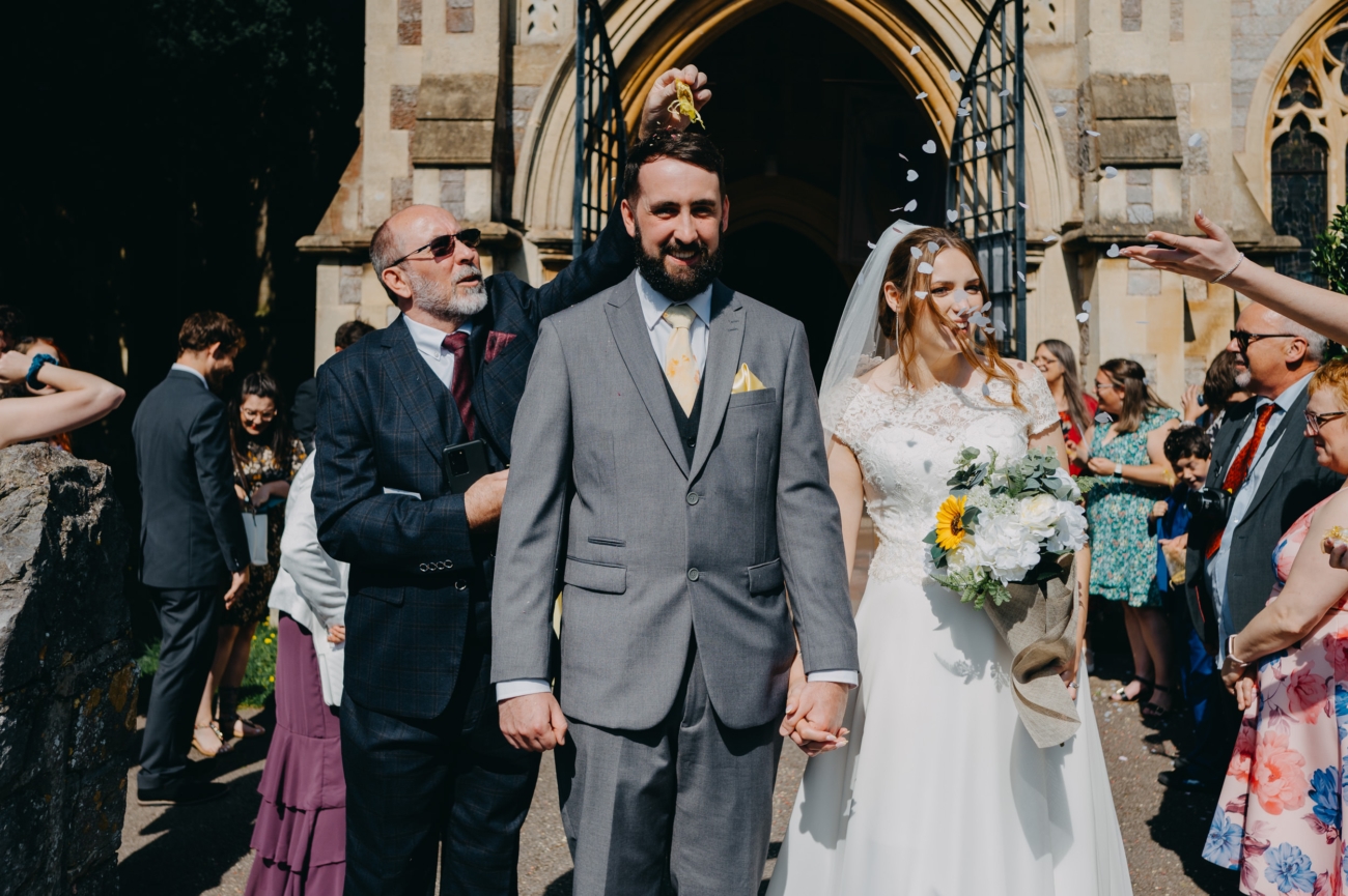 Just married couple leaving All Saints Church, Babbacombe, Torquay, as guests throw confetti.