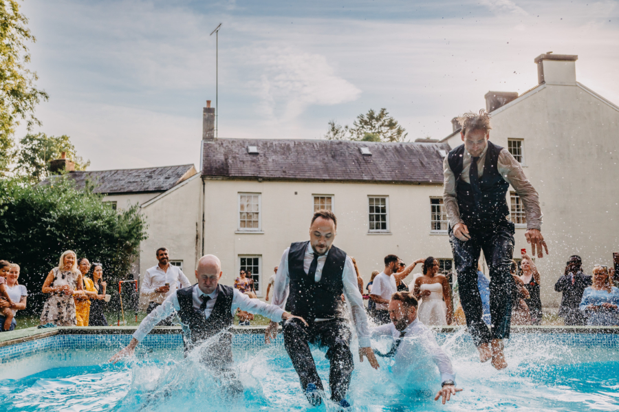 Groomsmen jumping into the pool – authentic storytelling through destination wedding photography