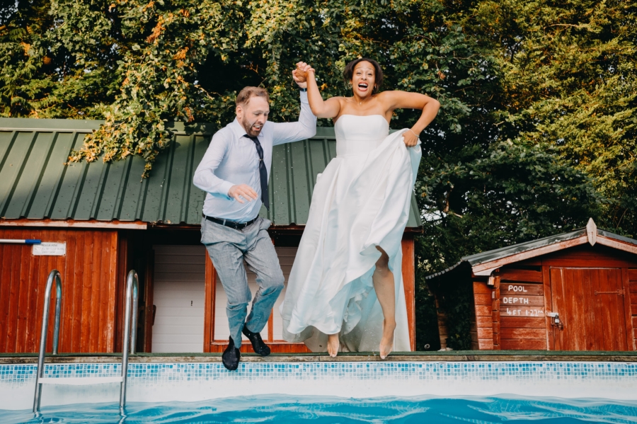 Bride and groom jumping into a pool – documentary destination wedding photography at its finest