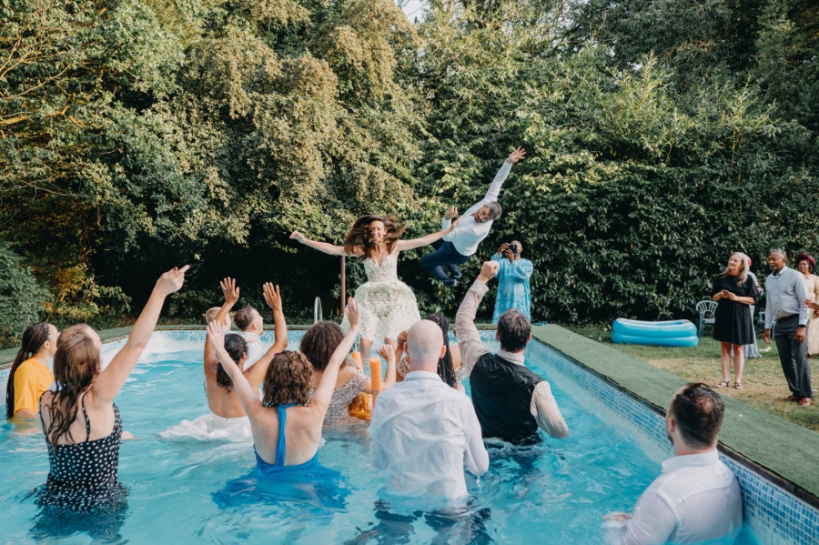 Wedding guests jumping into the pool – documentary destination wedding photography in full action