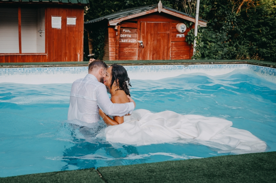 Candid photo of newlyweds embracing in the pool after their destination wedding splash