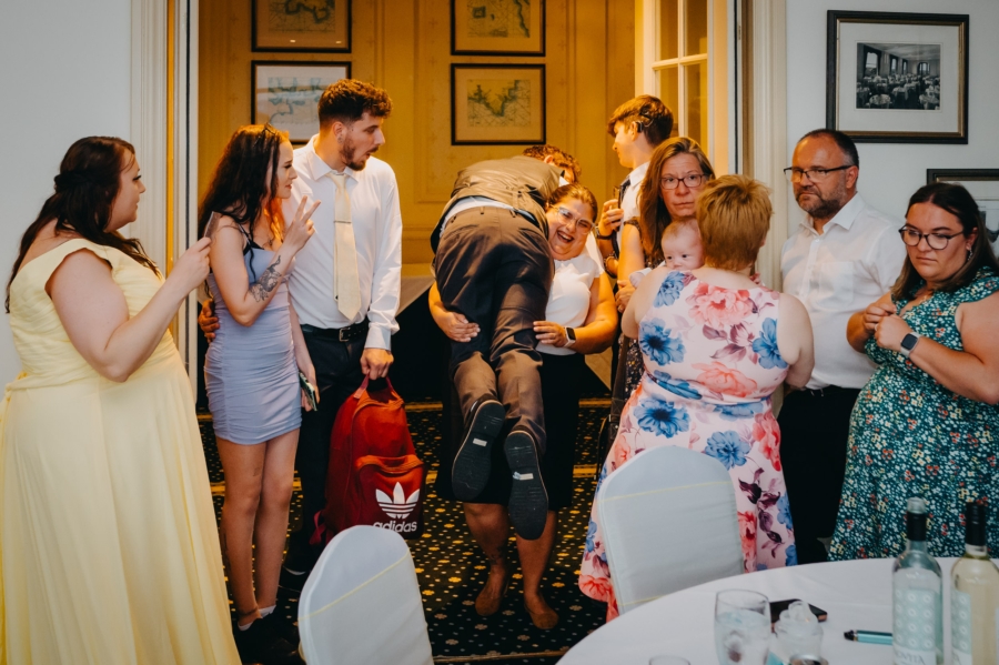 Group of wedding guests laughing during a fun and spontaneous moment at the reception