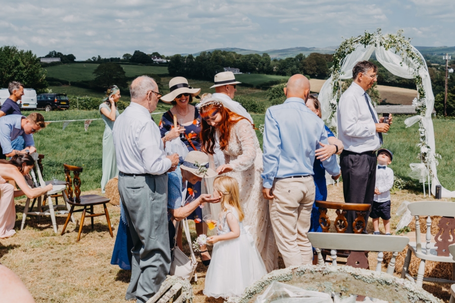 Bride greeting family and guests during a joyful outdoor wedding celebration