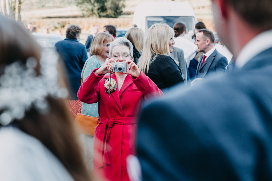 Elderly wedding guest taking a candid photo