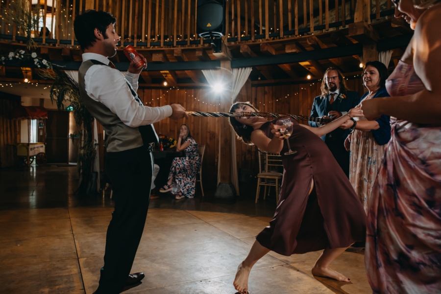Wedding guest playing limbo at reception – natural moment full of joy and spontaneity