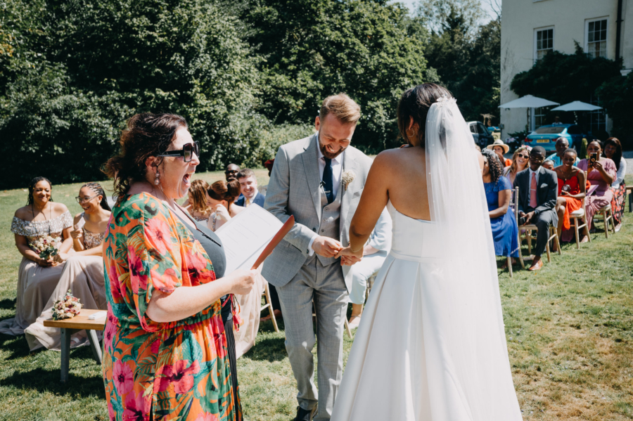 Bride and groom laughing during wedding ceremony outdoors