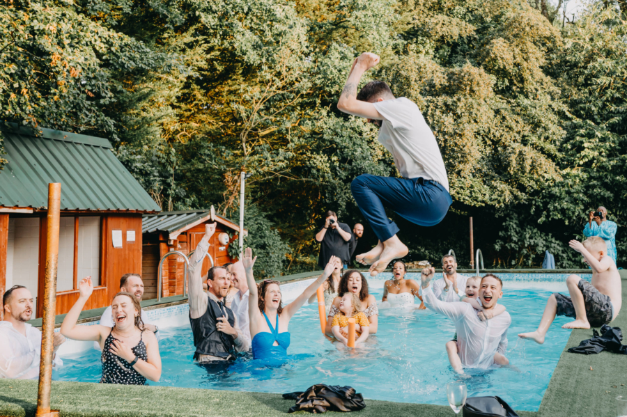 Wedding guests jumping into the pool – a spontaneous and joyful candid moment