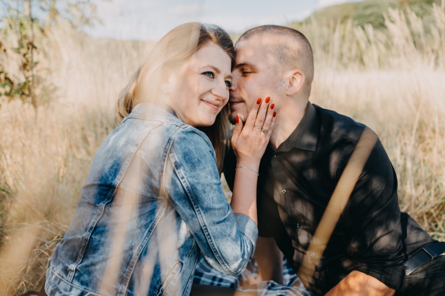 Candid couple photoshoot with natural laughter and gentle touch outdoors