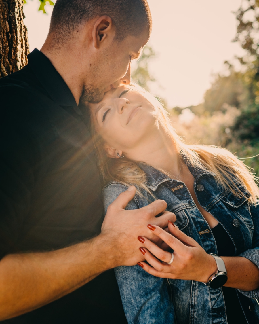 Emotional couple session with a gentle forehead kiss in natural light