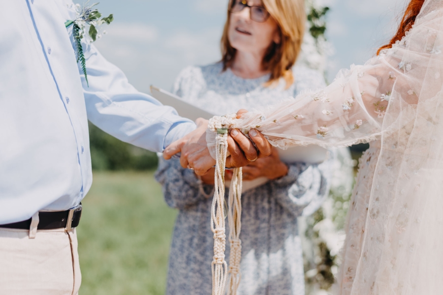 Handfasting during outdoor wedding ceremony in Wales