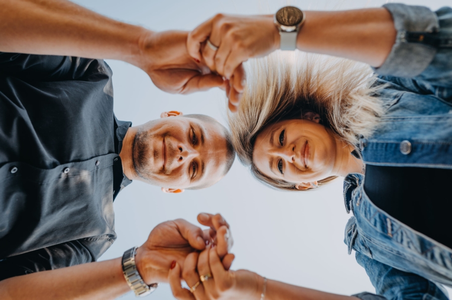 Outdoors couple session with playful hands and a creative low-angle perspective