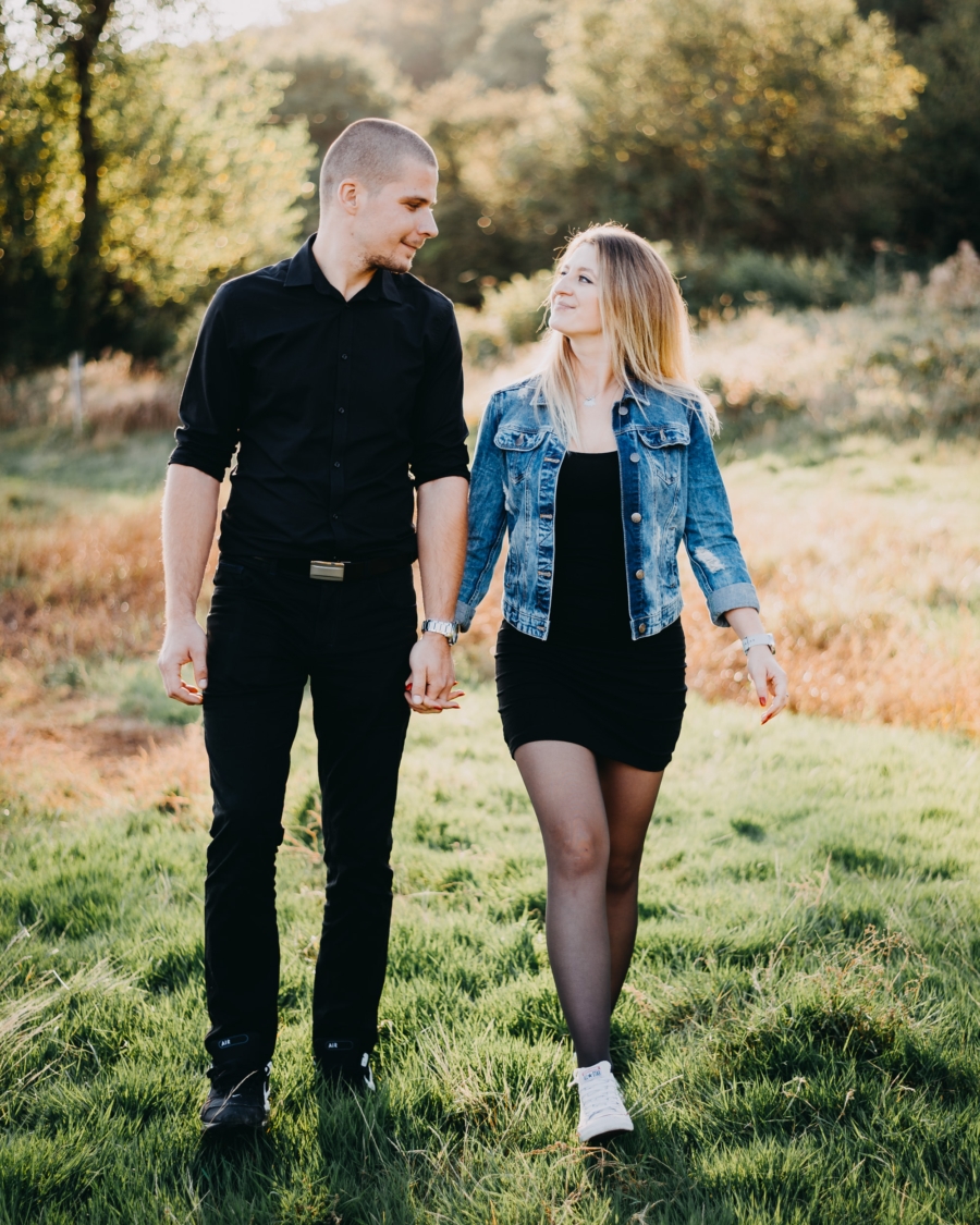 Outdoors couple session walking across a sunlit meadow together