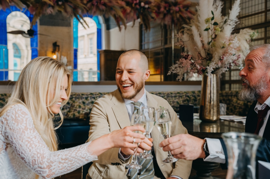 Bride and groom raising a toast after their tiny wedding in a Bristol