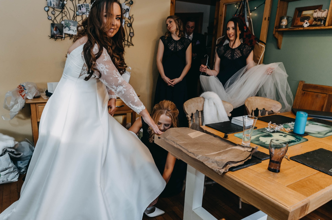 Bride getting ready with help from bridesmaids before her wedding in Myddfai – candid moment at home