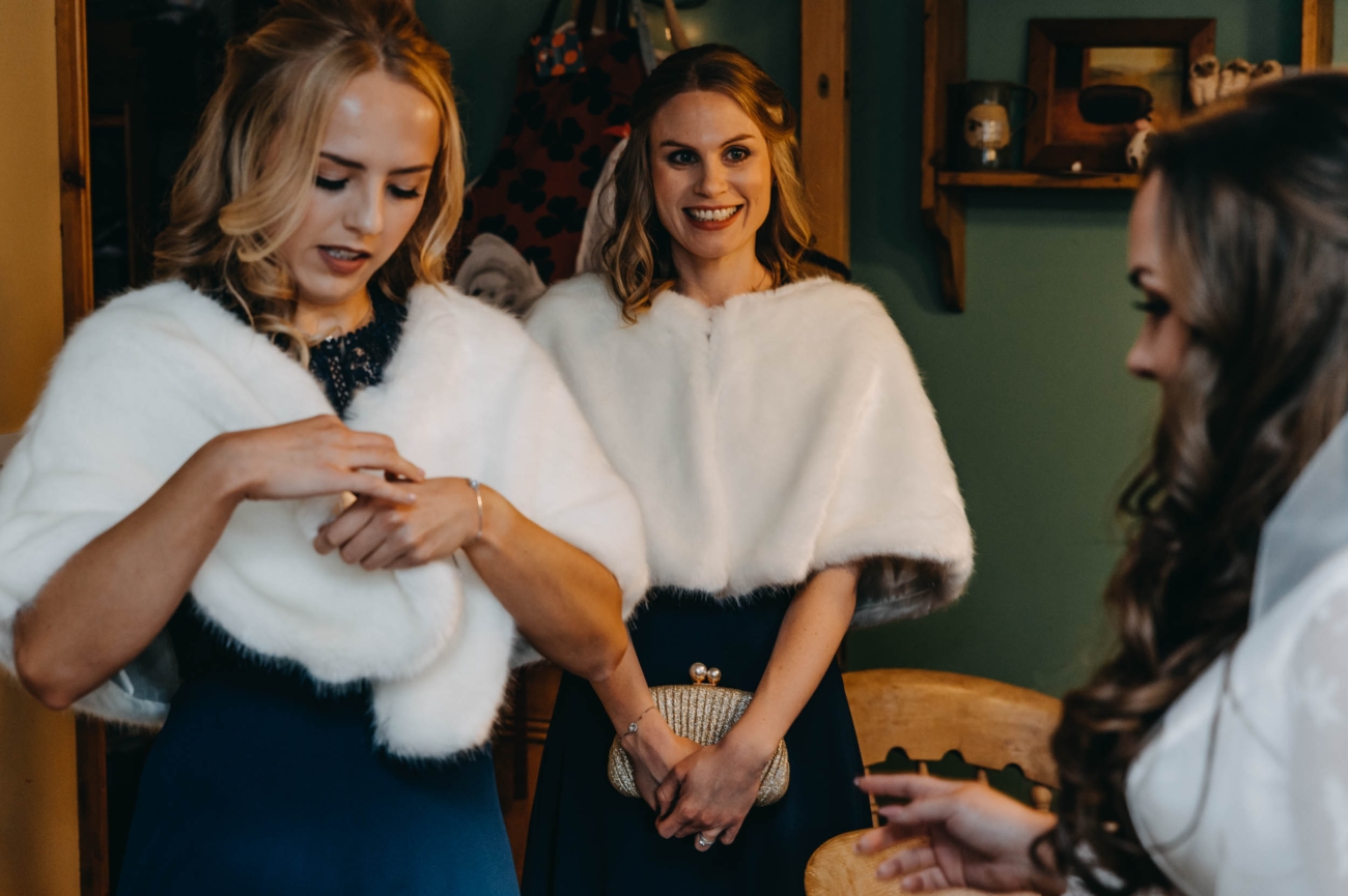 Bridesmaids wearing winter shawls before a countryside wedding in Myddfai