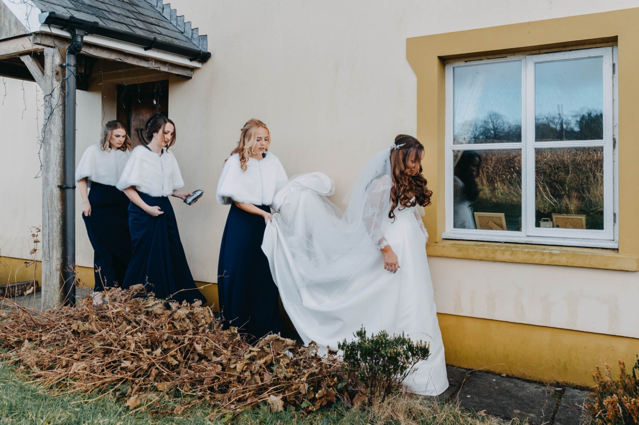 Bride walking with bridesmaids outside the house before wedding in Myddfai – candid winter moment