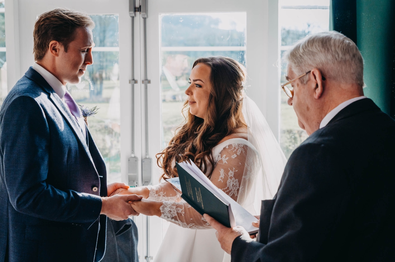 Bride and groom exchanging vows during their wedding ceremony at Myddfai Community Hall