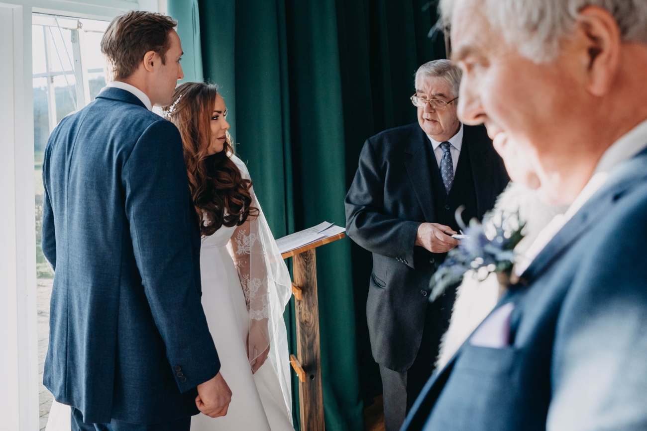 Bride and groom standing together during their wedding ceremony in Myddfai – candid moment with the celebrant