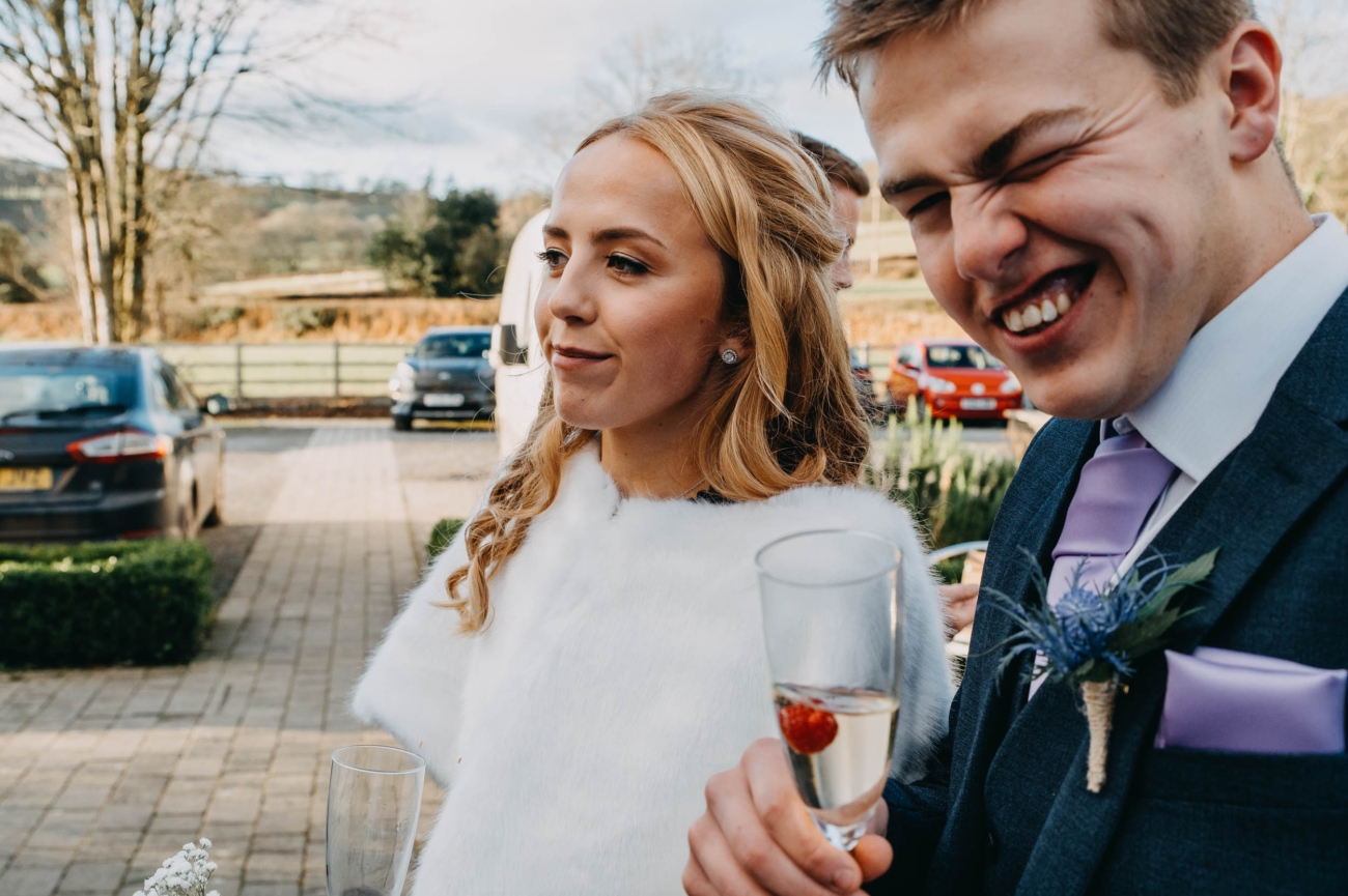 Wedding guests sharing a lighthearted moment during the reception in Myddfai – candid and joyful capture