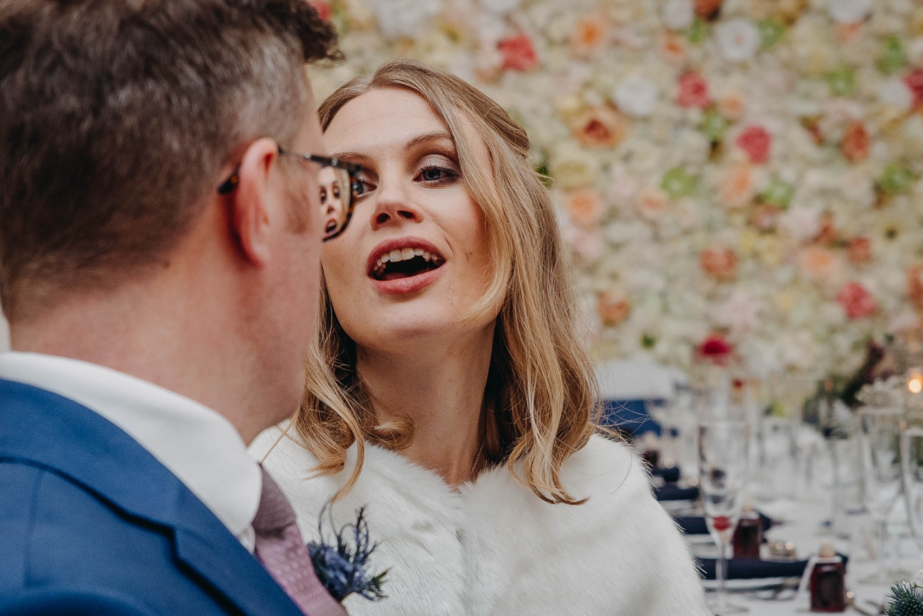 Guest mid-conversation during the wedding reception at Myddfai Community Hall – candid documentary-style moment