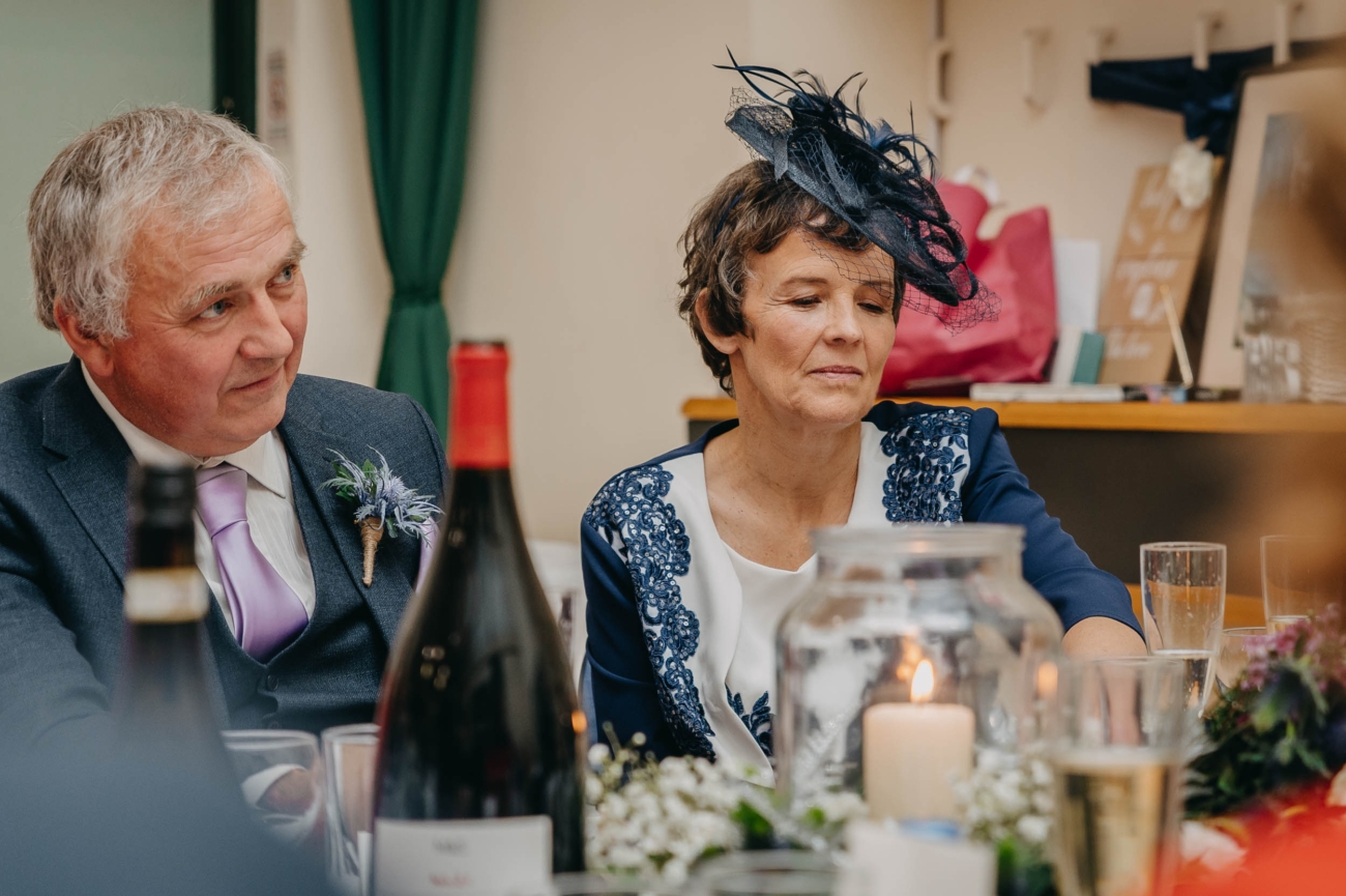 Parents of the bride listening quietly during the wedding reception speeches at Myddfai Community Hall