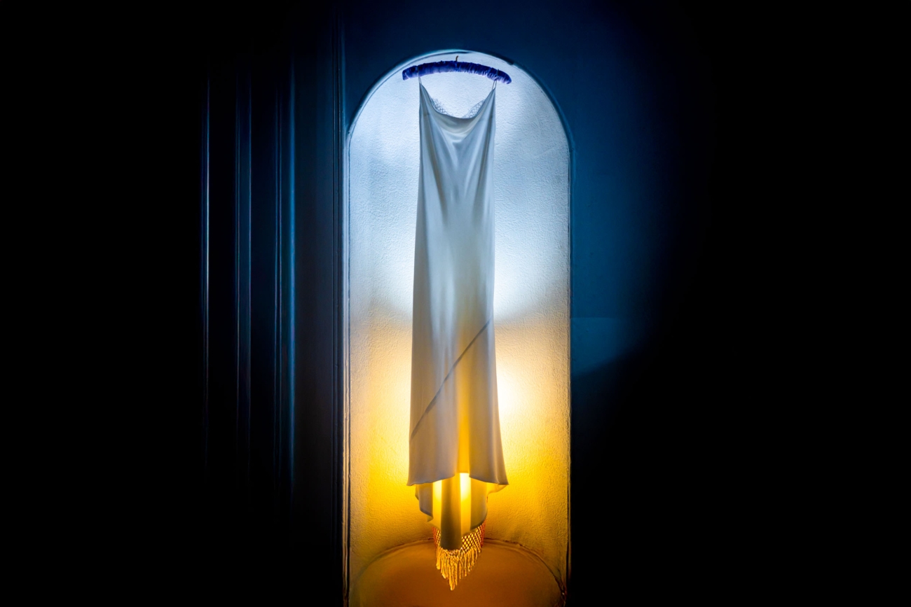 White wedding dress illuminated by contrasting blue and amber light, exploring how lighting changes colour perception.