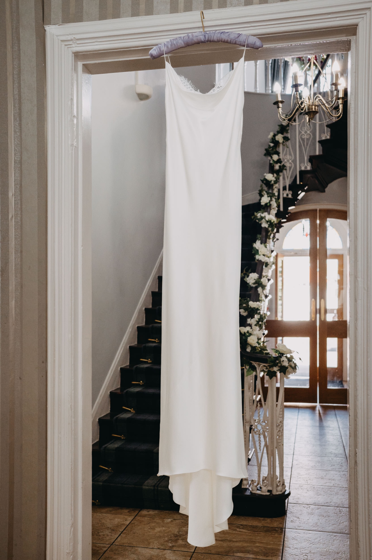 White wedding dress hanging in natural daylight, showing how lighting affects colour perception.