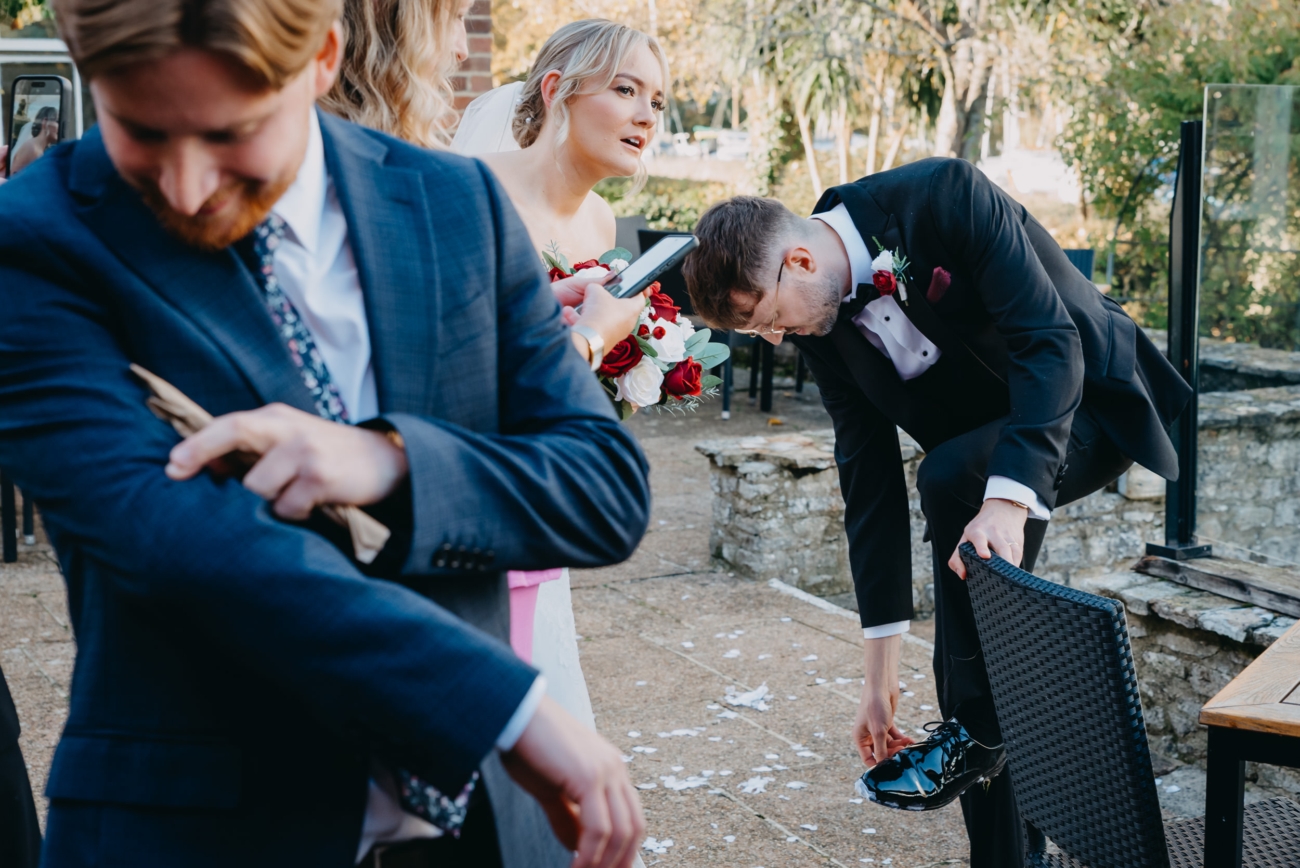 Bride and groom adjusting clothes just after the confetti moment