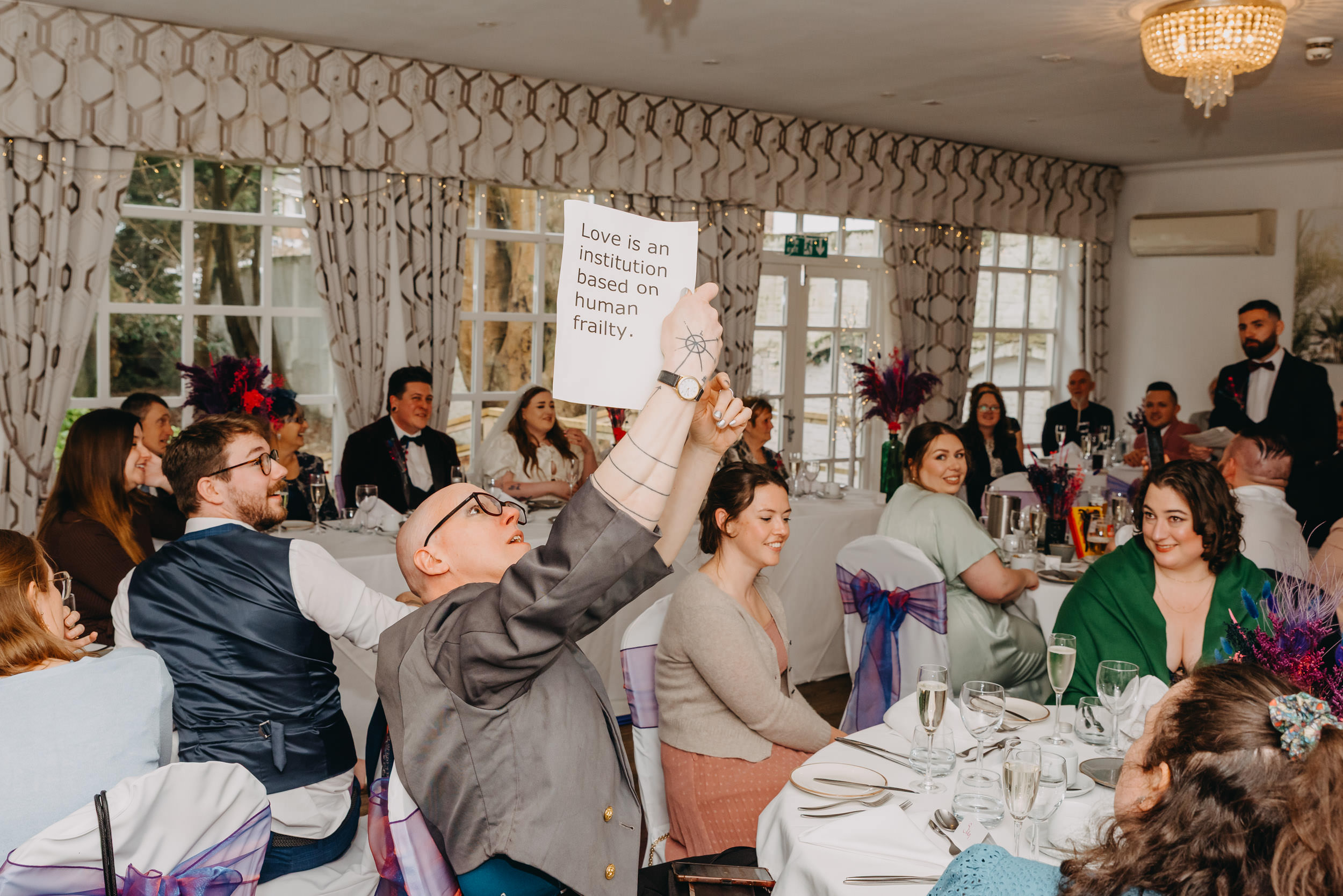 Guest holding a handwritten sign during an unscripted wedding speech