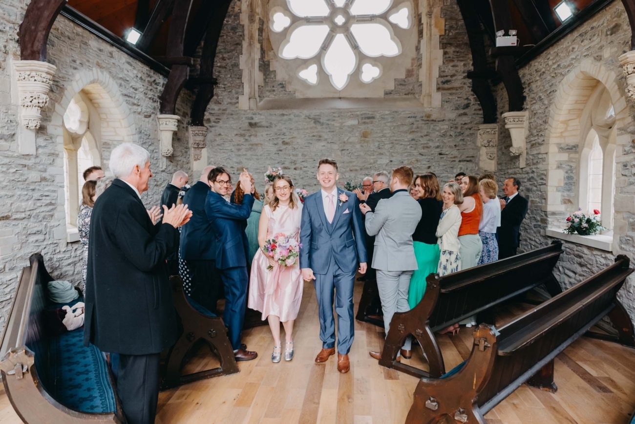 Couple walking down the aisle after the ceremony surrounded by guests during full day wedding